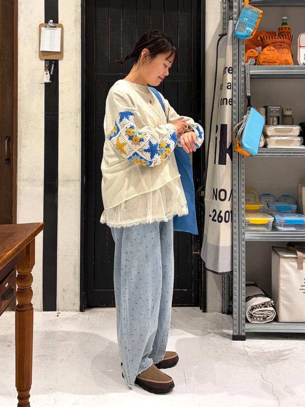 ベージュ系のスウェット、ブルー系のトートバッグ、ブルー系のデニムパンツを着用したレディースの春コーディネートの5枚目の写真