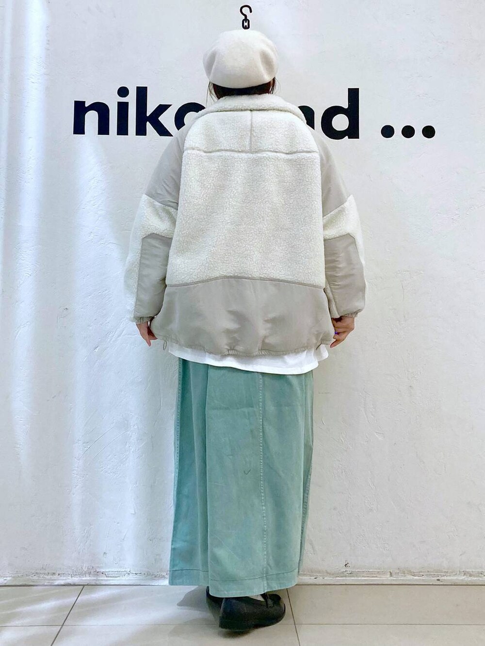 ベージュ系のベスト、ベージュ系のブルゾン、グリーン系のスカートを着用したレディースの冬コーディネートの5枚目の写真