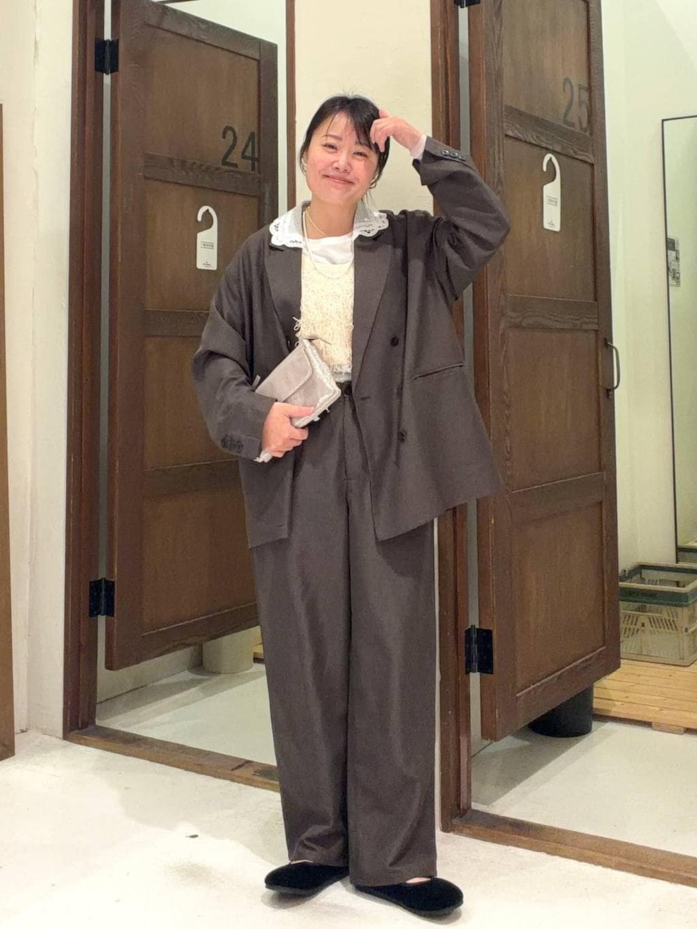 グレー系のショルダーバッグ、ブラック系のパンプス、ブラウン系のテーラードジャケットを着用したレディースの冬コーディネートの3枚目の写真