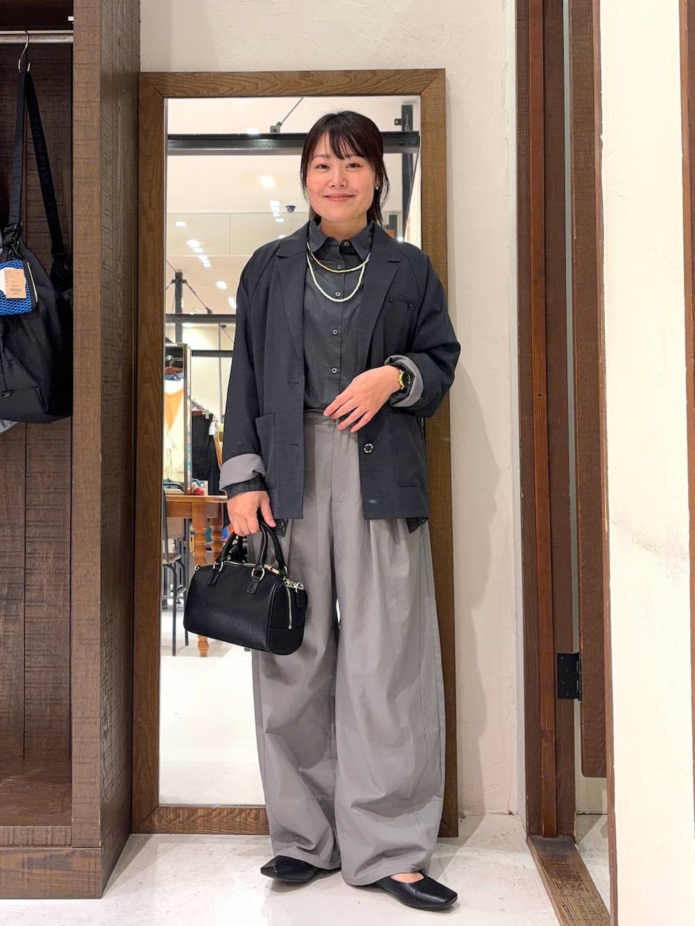 ブラック系のボストンバッグ、グレー系のシャツ/ブラウス、イエロー系のネックレスを着用したレディースの冬コーディネートの3枚目の写真