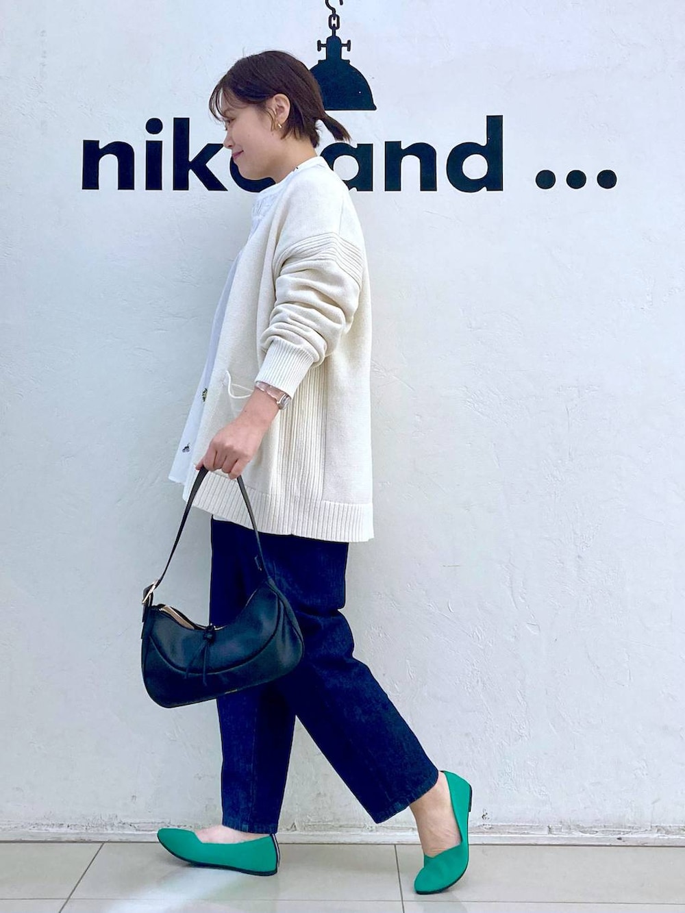 ブラック系のショルダーバッグ、ホワイト系のシャツ/ブラウス、グリーン系のパンプスを着用したレディースの春コーディネートの5枚目の写真