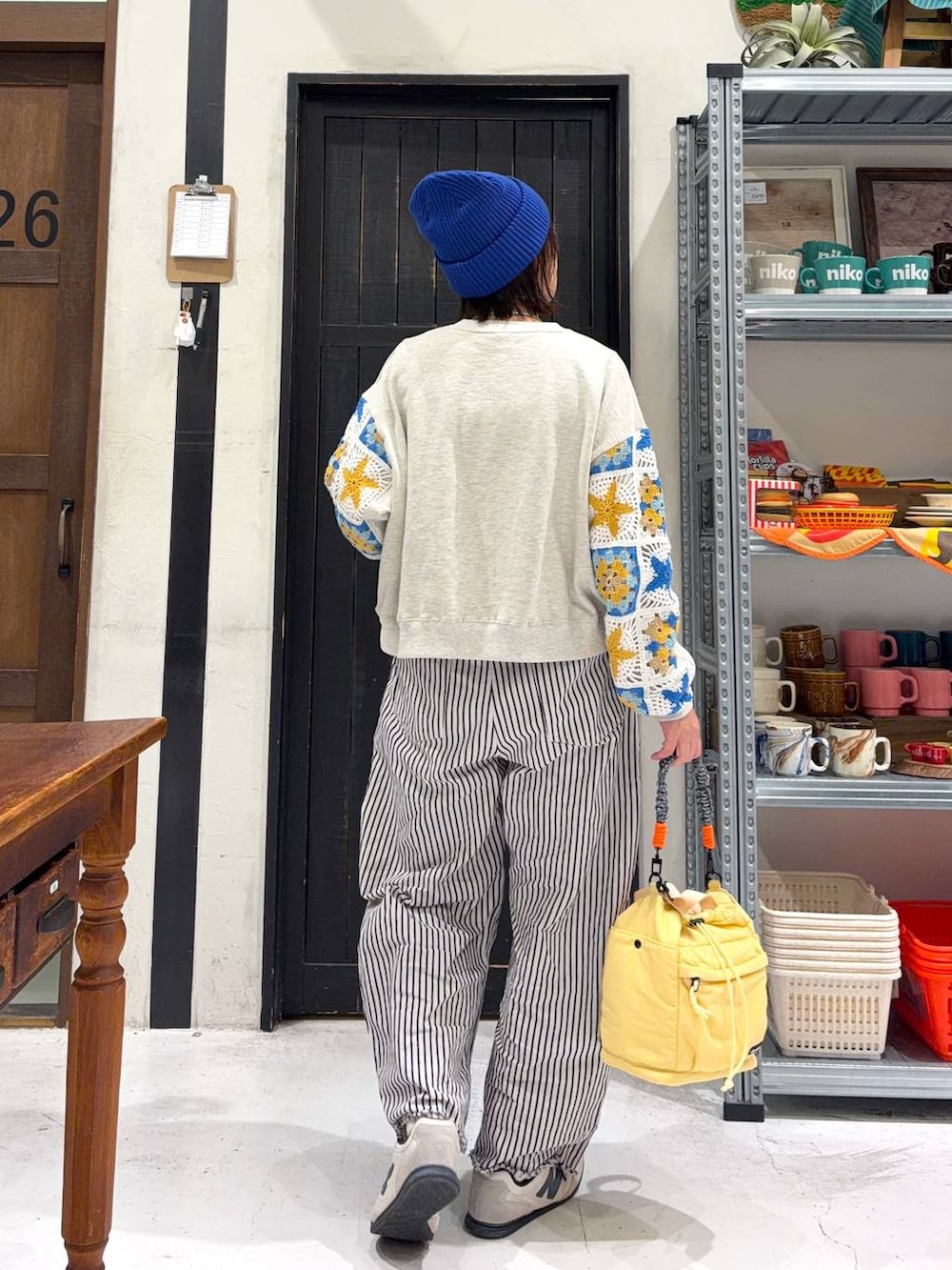 イエロー系のショルダーバッグ、ホワイト系のデニムパンツ、ブルー系のニットキャップ/ビーニーを着用したレディースの冬コーディネートの4枚目の写真