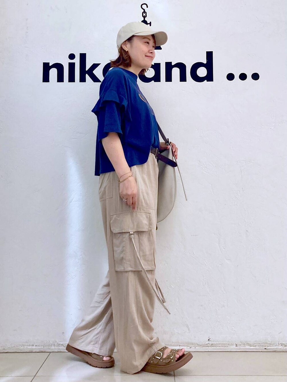 ベージュ系のサンダル、ブルー系のTシャツ/カットソー、グレー系のショルダーバッグを着用したレディースの夏コーディネートの5枚目の写真