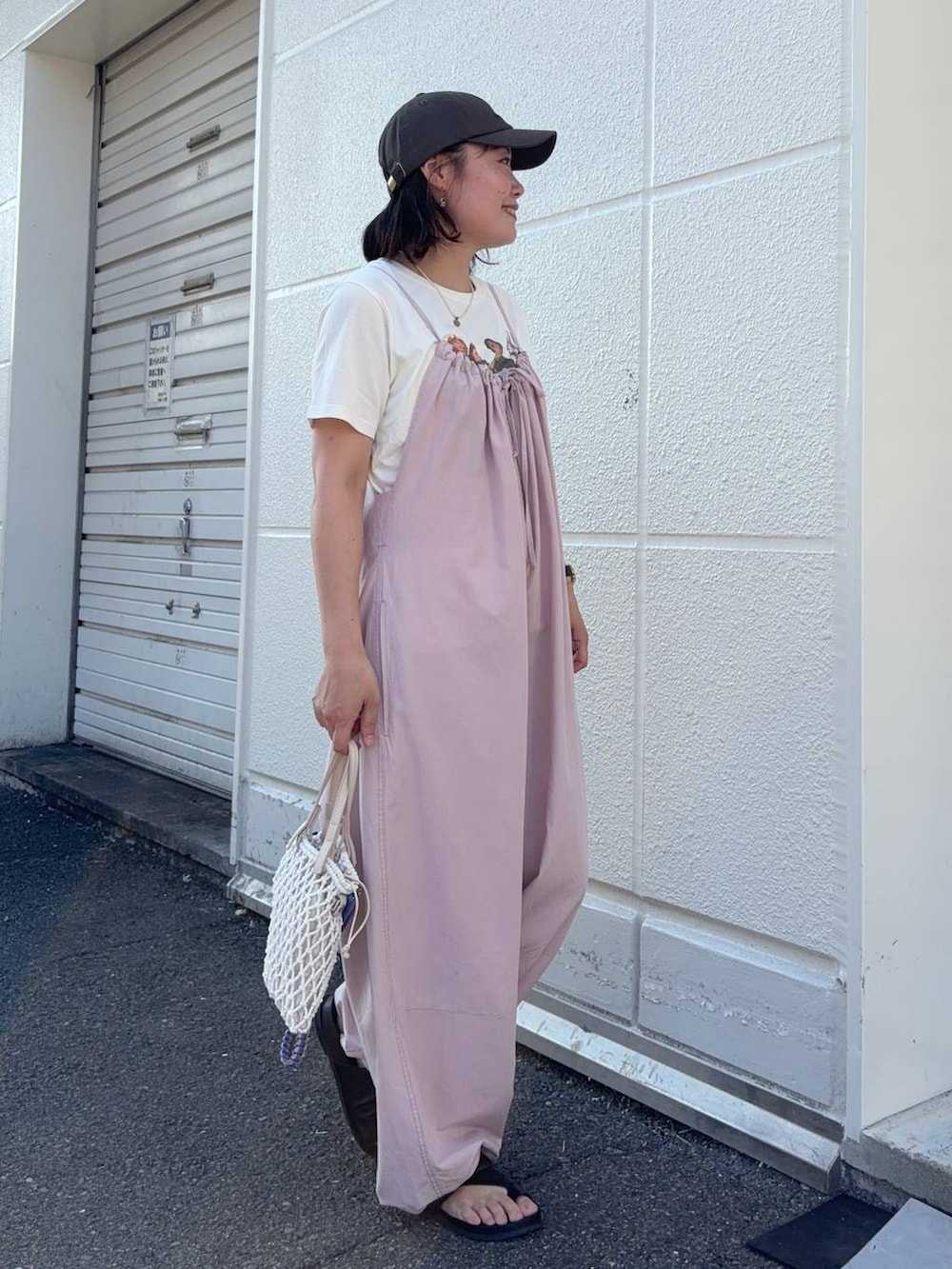 ピンク系のサロペット/オーバーオール、ベージュ系のトートバッグ、ベージュ系のTシャツ/カットソーを着用したレディースの夏コーディネートの4枚目の写真
