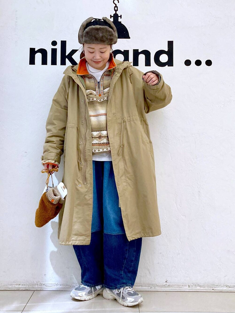 イエロー系のモッズコート、ブルー系のデニムパンツ、ホワイト系のTシャツ/カットソーを着用したレディースの秋コーディネートの2枚目の写真