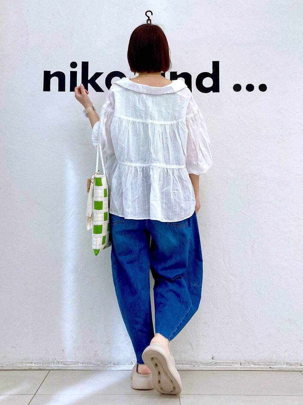 ベージュ系のサンダル、ブルー系のデニムパンツ、グリーン系のタンクトップを着用したレディースの夏コーディネートの4枚目の写真