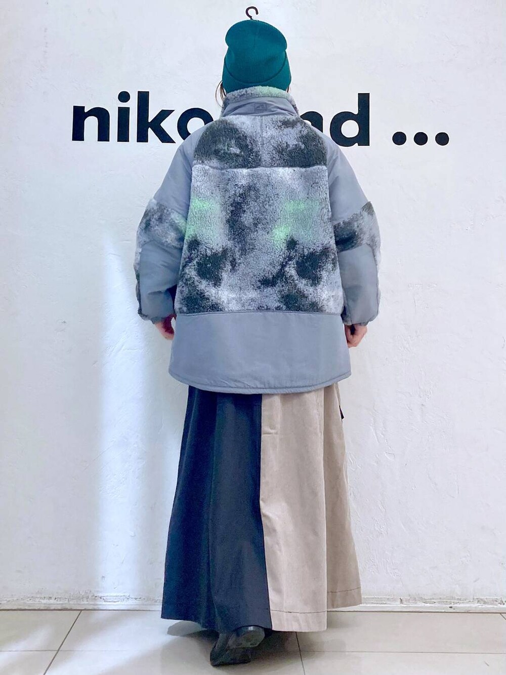 グレー系のブルゾン、ホワイト系のTシャツ/カットソー、グレー系のニット/セーターを着用したレディースの冬コーディネートの4枚目の写真