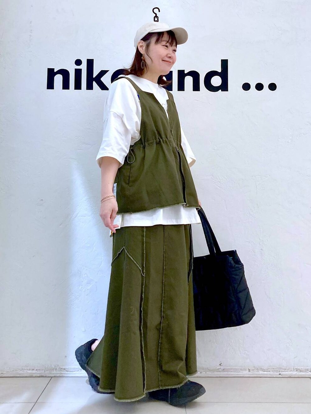 ブラック系のトートバッグ、ホワイト系のTシャツ/カットソー、ゴールド系のブレスレットを着用したレディースの春コーディネートの5枚目の写真