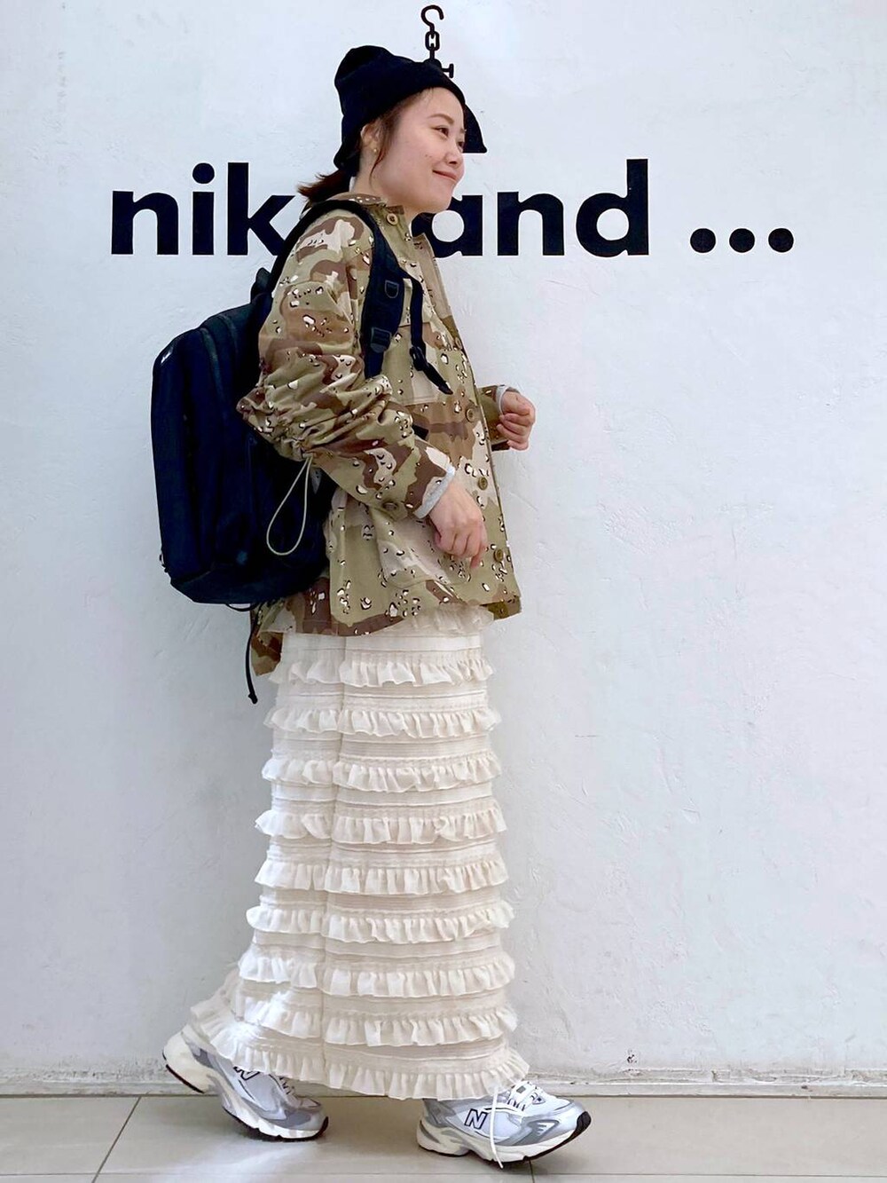 グレー系のスニーカー、ベージュ系のスカート、グレー系のバックパック/リュックを着用したレディースの秋コーディネートの5枚目の写真