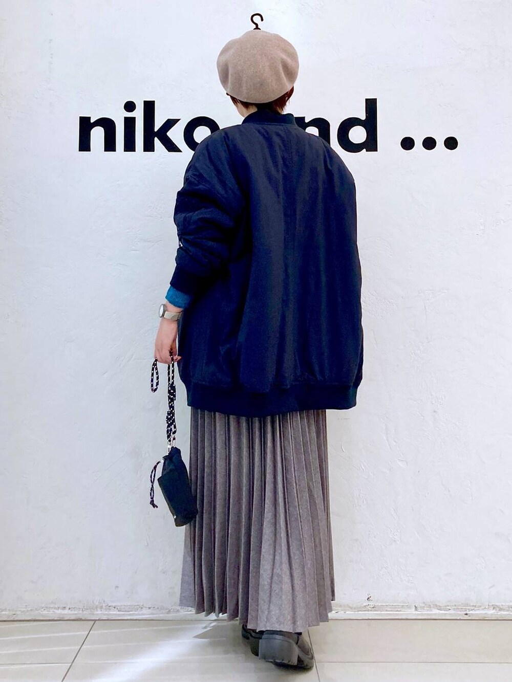 ブラック系のMA-1、グリーン系のニット/セーター、ブラック系のブーツを着用したレディースの冬コーディネートの3枚目の写真