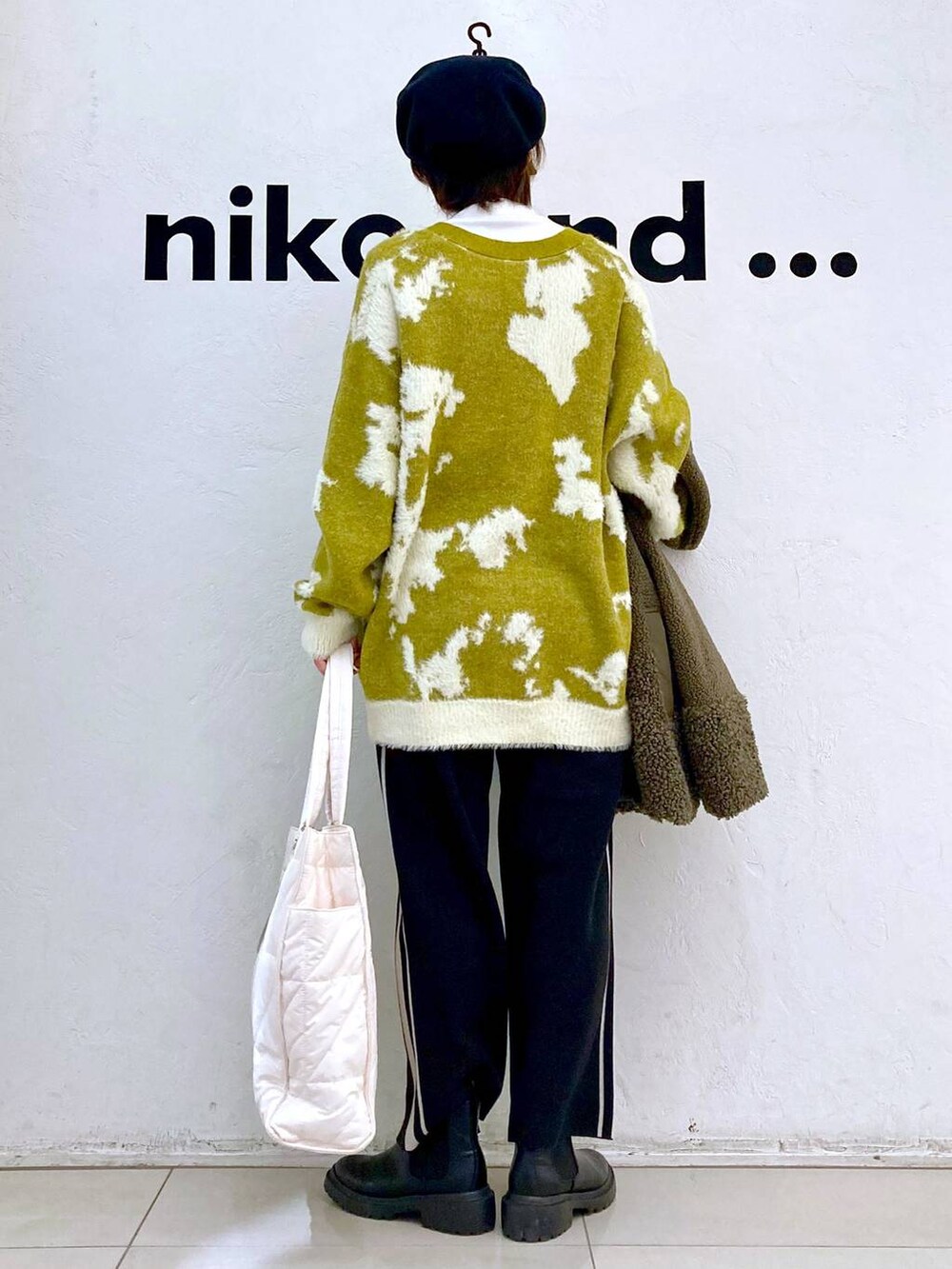 グリーン系のその他アウター、ホワイト系のその他パンツ、ブラック系のブーツを着用したレディースの冬コーディネートの4枚目の写真