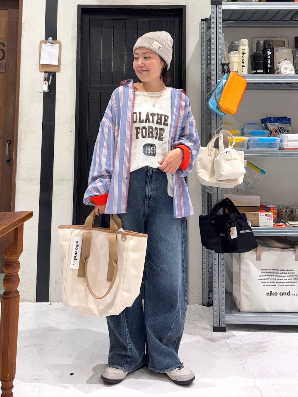 ブルー系のデニムパンツ、ホワイト系のタンクトップ、その他のトートバッグを着用したレディースの春コーディネートの2枚目の写真