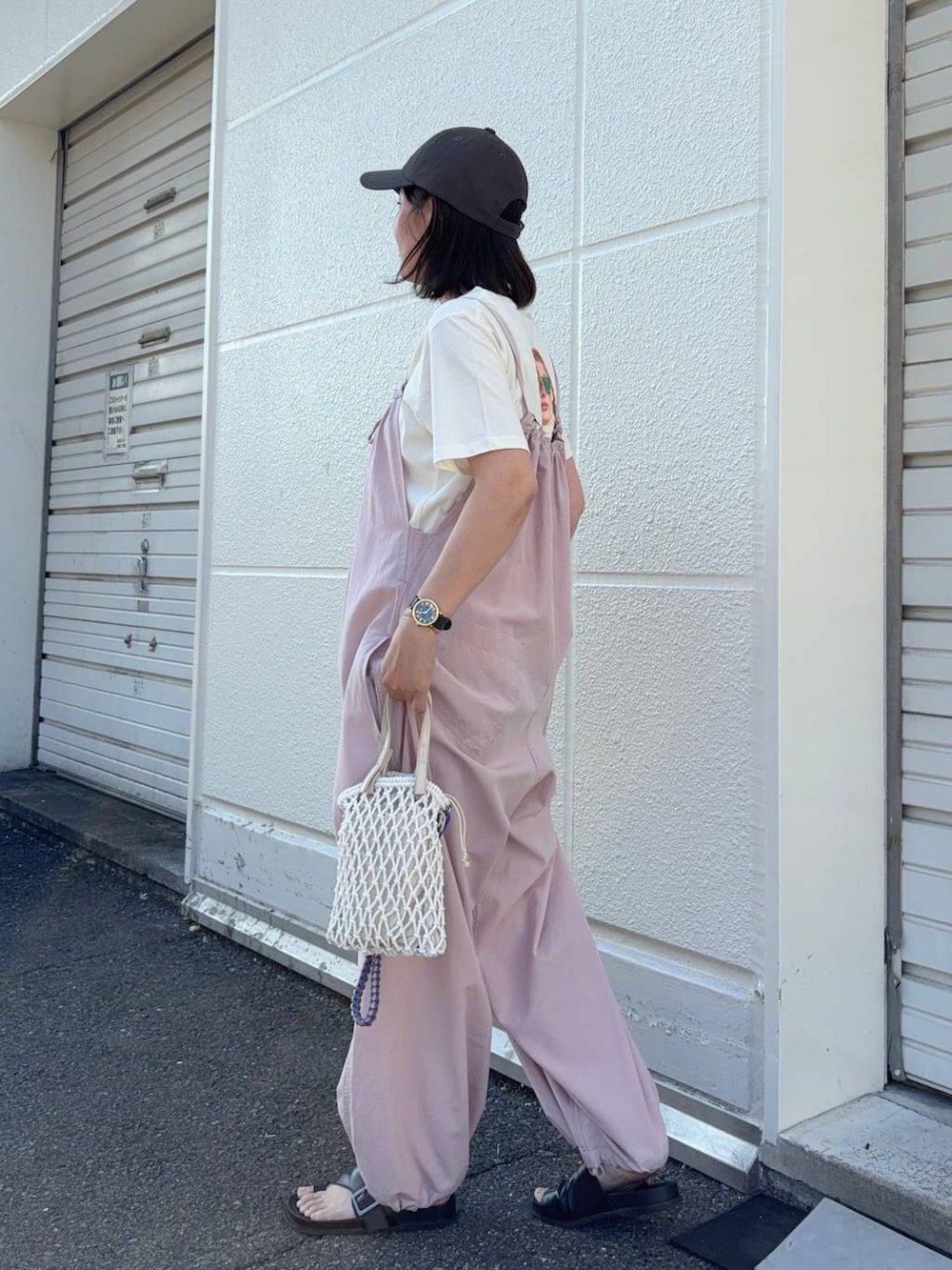 ピンク系のサロペット/オーバーオール、ベージュ系のトートバッグ、ベージュ系のTシャツ/カットソーを着用したレディースの夏コーディネートの3枚目の写真