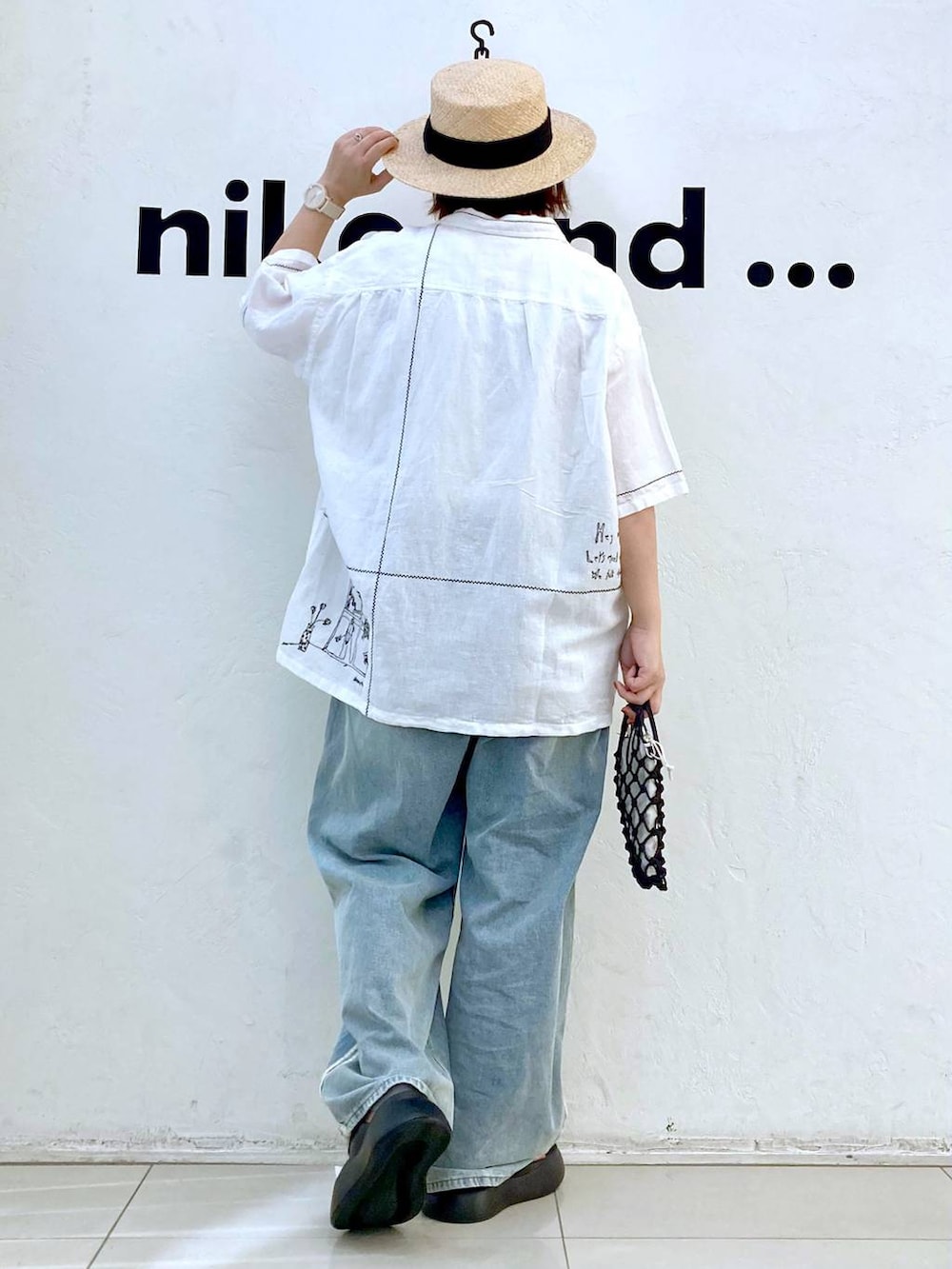 ブラック系のショルダーバッグ、ブラック系のサンダル、ホワイト系のTシャツ/カットソーを着用したレディースの春コーディネートの3枚目の写真