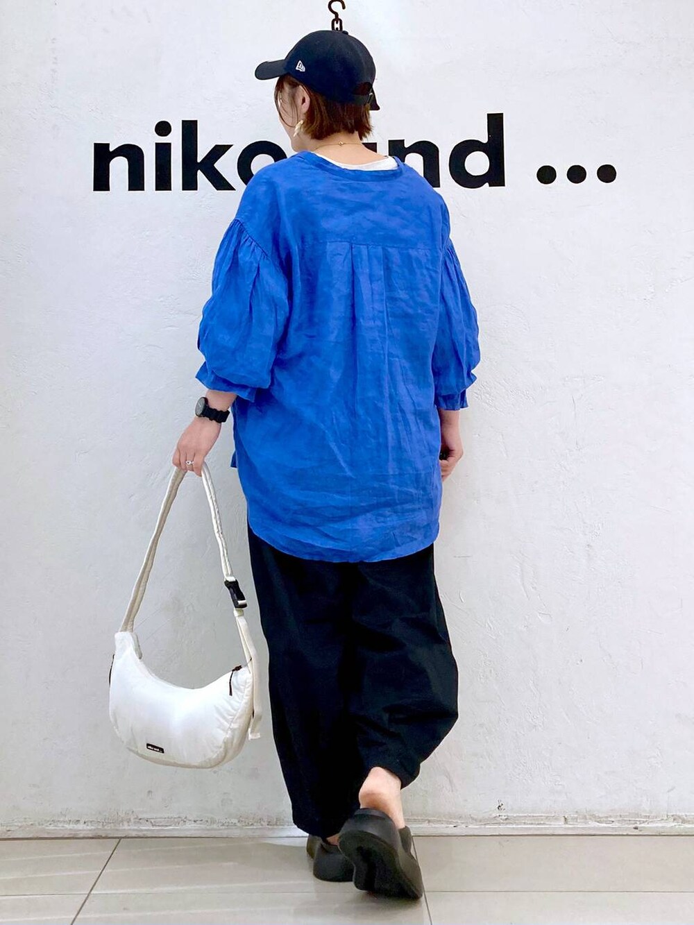 ブラック系のサンダル、ベージュ系のTシャツ/カットソー、ホワイト系のショルダーバッグを着用したレディースの春コーディネートの4枚目の写真
