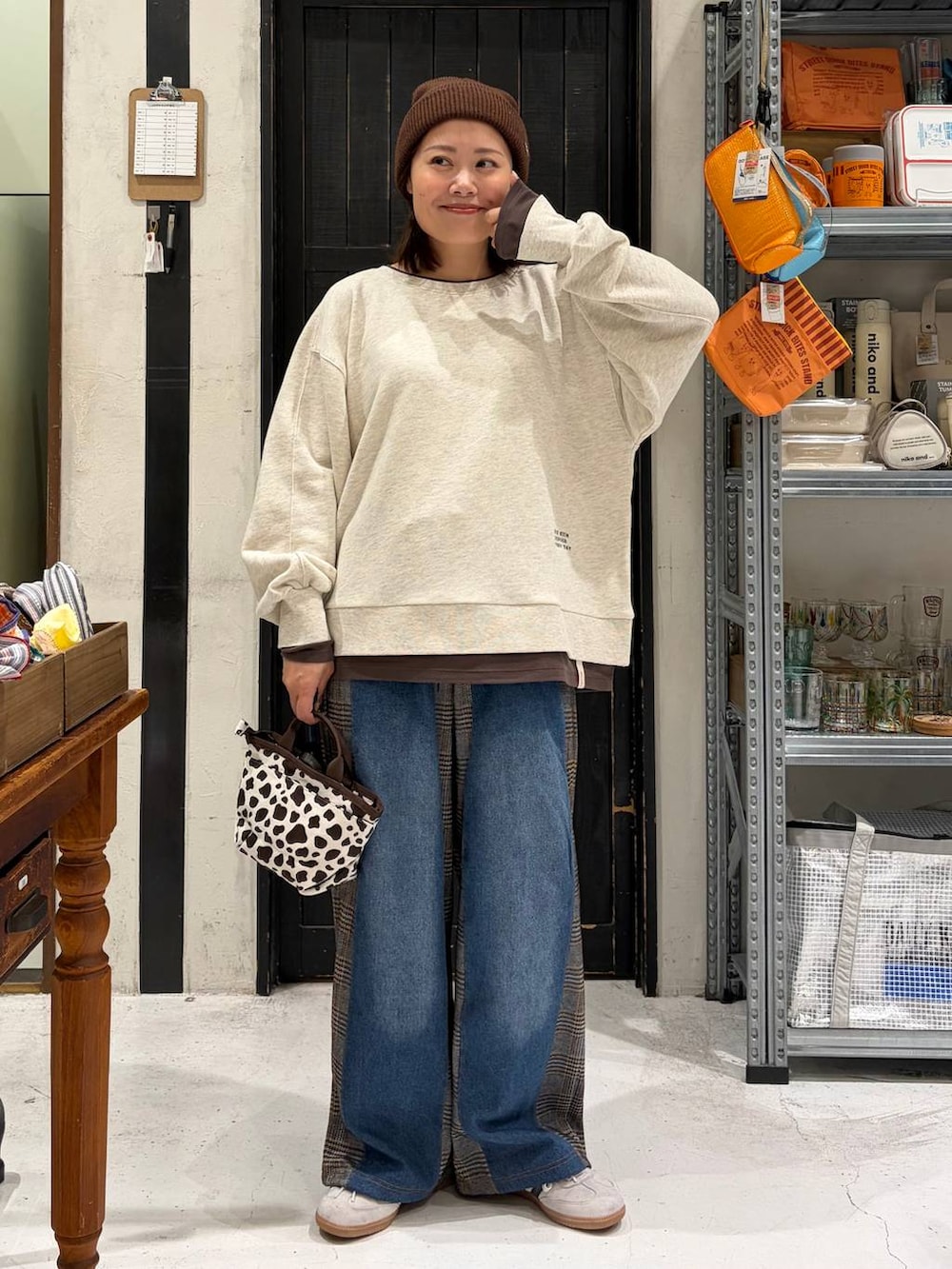 その他のトートバッグ、ブラウン系のデニムパンツ、ベージュ系のスウェットを着用したレディースの秋コーディネートの2枚目の写真
