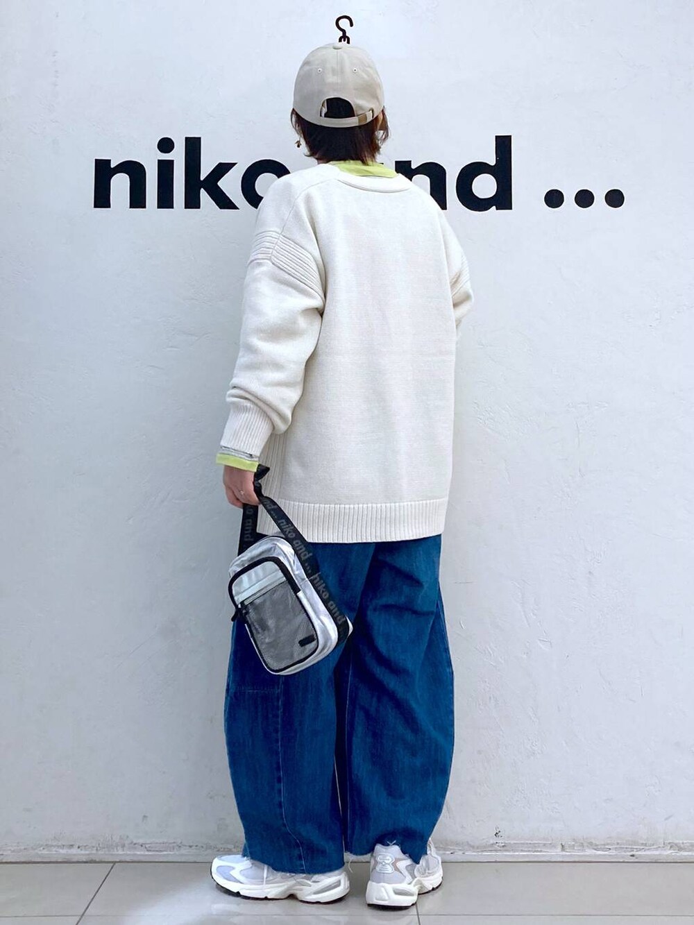 グレー系のショルダーバッグ、イエロー系のTシャツ/カットソー、ベージュ系のカーディガン/ボレロを着用したレディースの冬コーディネートの3枚目の写真