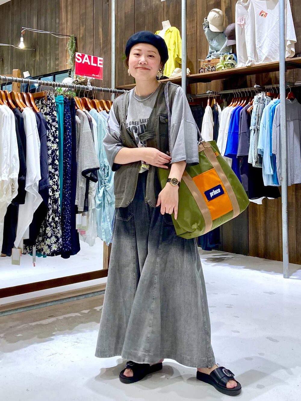 グレー系のスカート、ブラック系のサンダル、グレー系のTシャツ/カットソーを着用したレディースの夏コーディネートの2枚目の写真