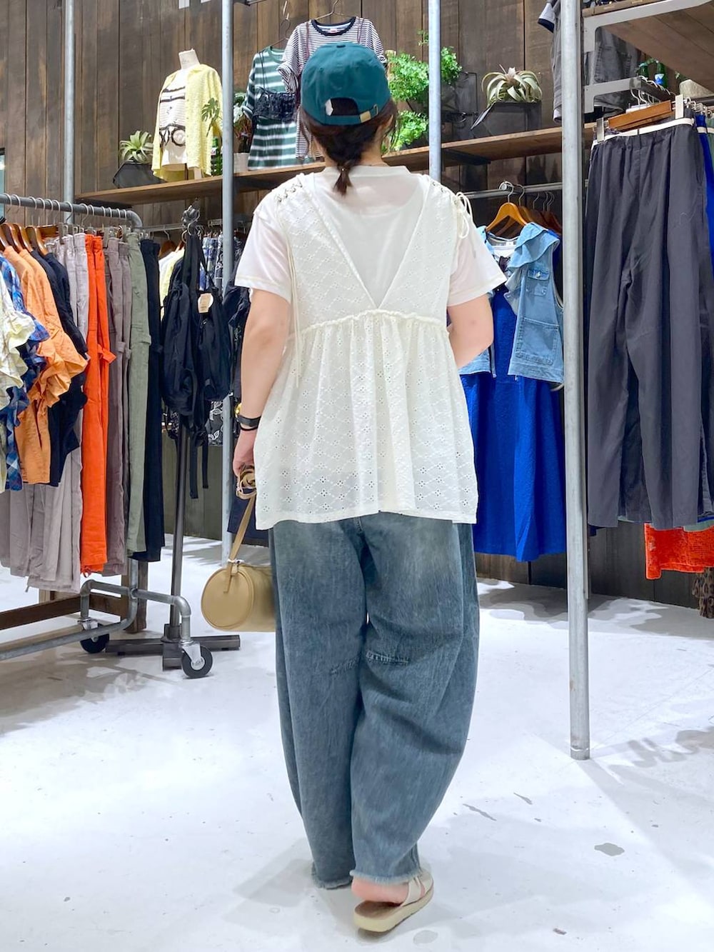 ブルー系のその他パンツ、ホワイト系のベスト、ベージュ系のショルダーバッグを着用したレディースの夏コーディネートの4枚目の写真