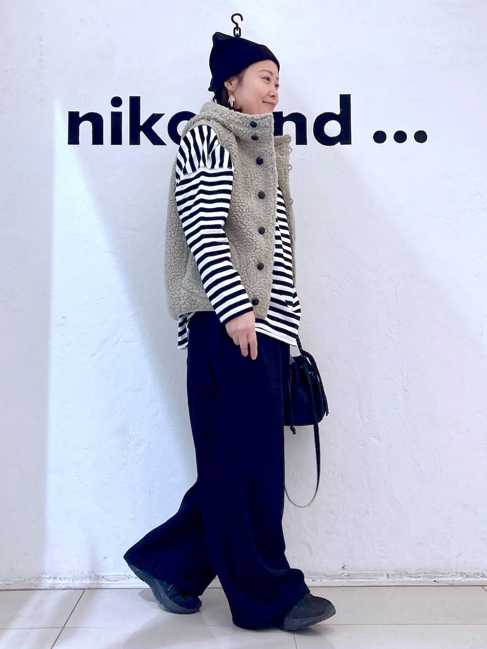 ベージュ系のベスト、ブラック系のその他パンツ、ブラック系のショルダーバッグを着用したレディースの冬コーディネートの5枚目の写真