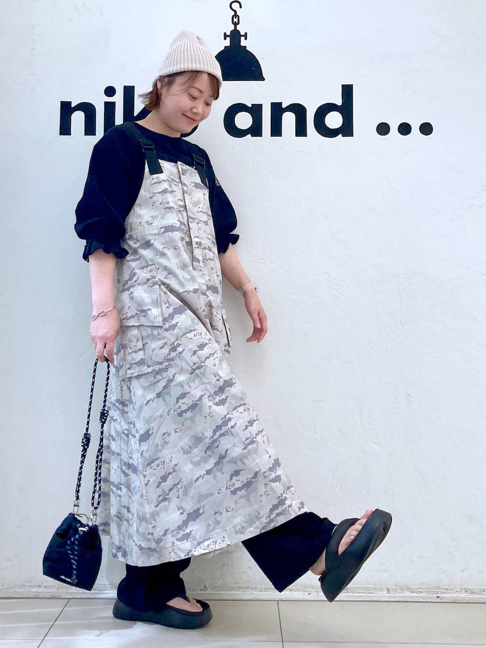 ブラック系のショルダーバッグ、ブラック系のサンダル、ブラック系のTシャツ/カットソーを着用したレディースの春コーディネートの3枚目の写真