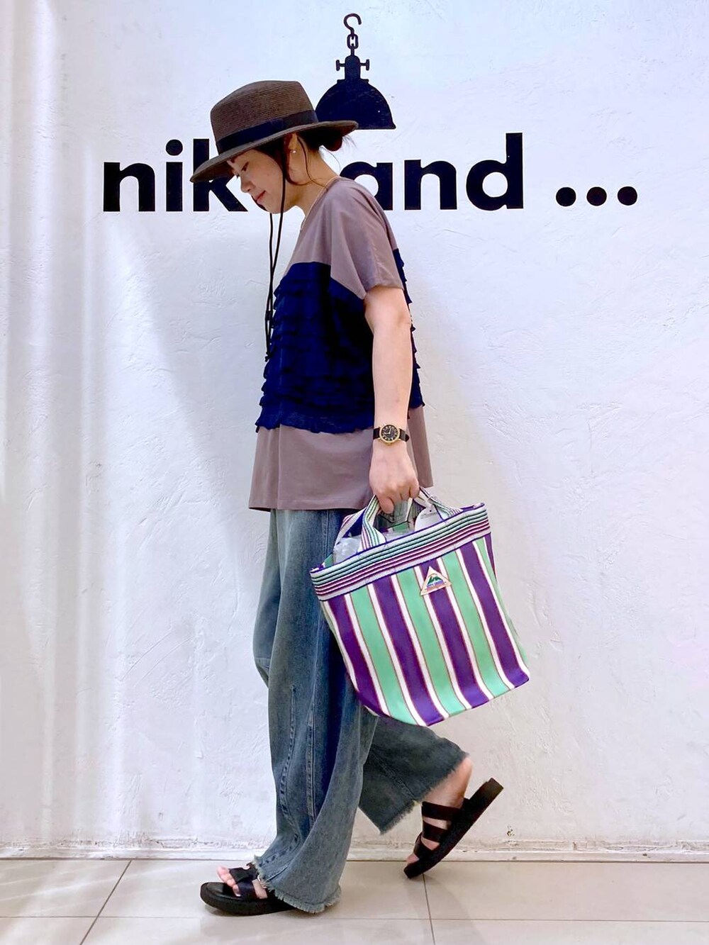 ブルー系のその他パンツ、グリーン系のトートバッグ、ブラウン系のTシャツ/カットソーを着用したレディースの夏コーディネートの3枚目の写真