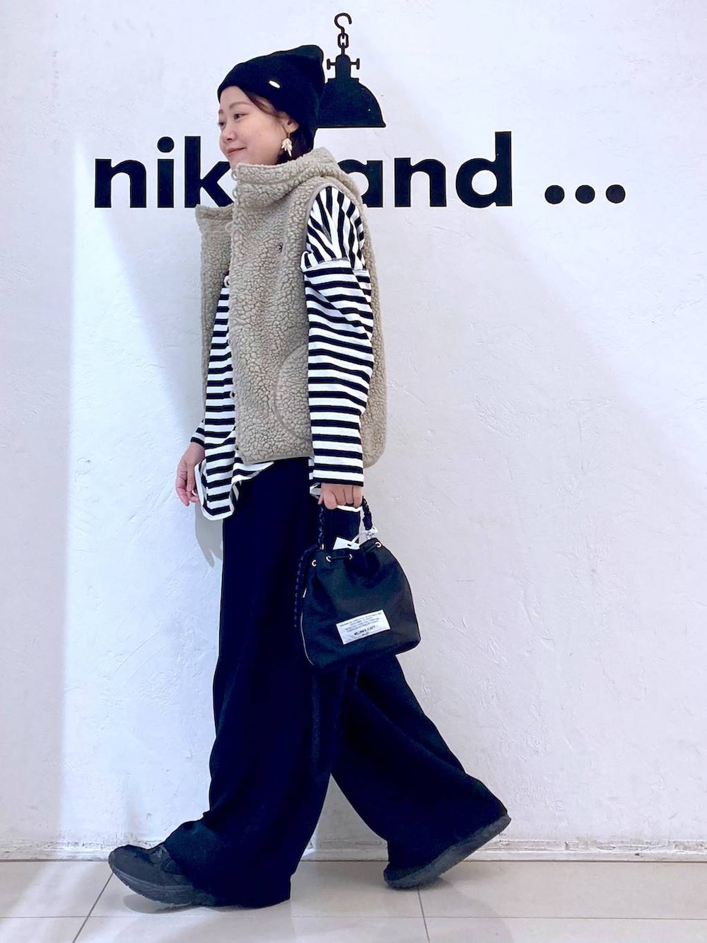 ベージュ系のベスト、ブラック系のその他パンツ、ブラック系のショルダーバッグを着用したレディースの冬コーディネートの3枚目の写真