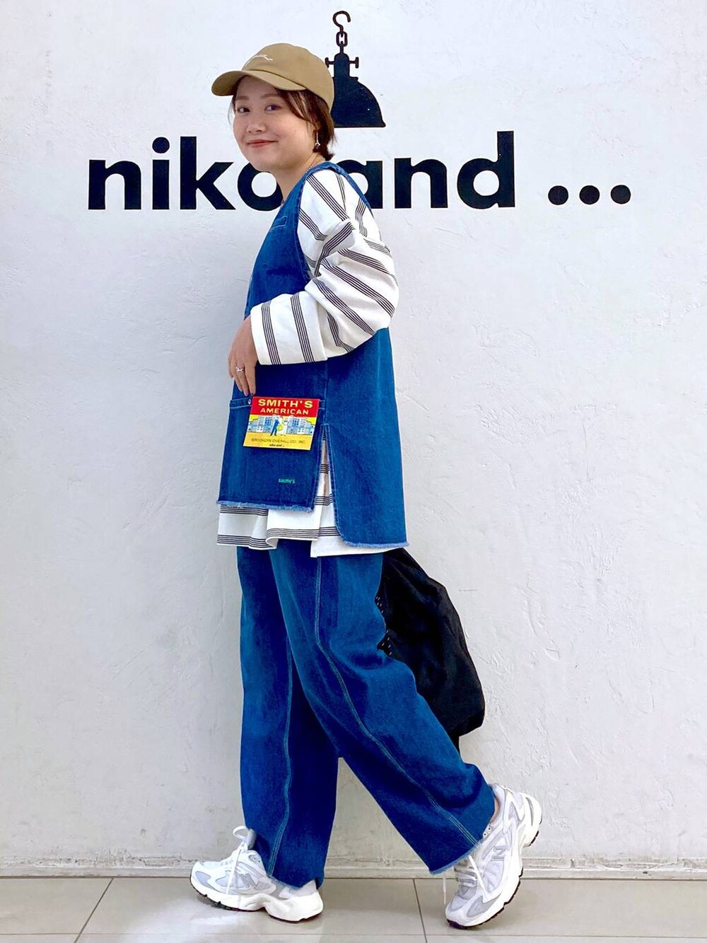 ブラック系のバックパック/リュック、ホワイト系のTシャツ/カットソー、ホワイト系のスニーカーを着用したレディースの冬コーディネートの2枚目の写真