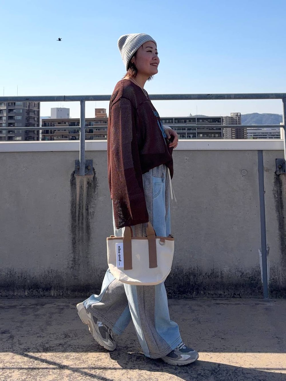 グレー系のデニムパンツ、ホワイト系のTシャツ/カットソー、その他のショルダーバッグを着用したレディースの春コーディネートの5枚目の写真