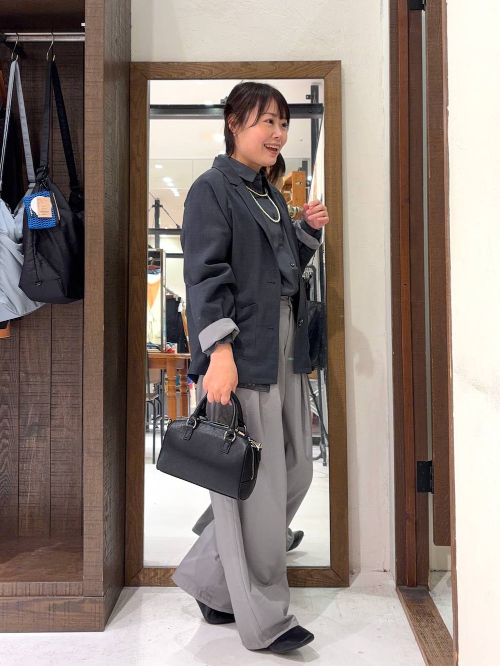 ブラック系のボストンバッグ、グレー系のシャツ/ブラウス、イエロー系のネックレスを着用したレディースの冬コーディネートの5枚目の写真