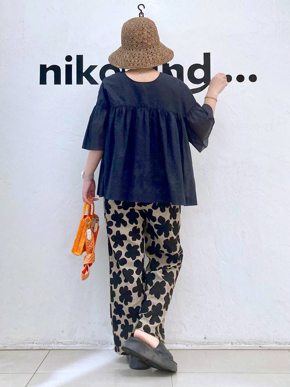 オレンジ系のショルダーバッグ、ブラック系のサンダル、その他のTシャツ/カットソーを着用したレディースの春コーディネートの4枚目の写真