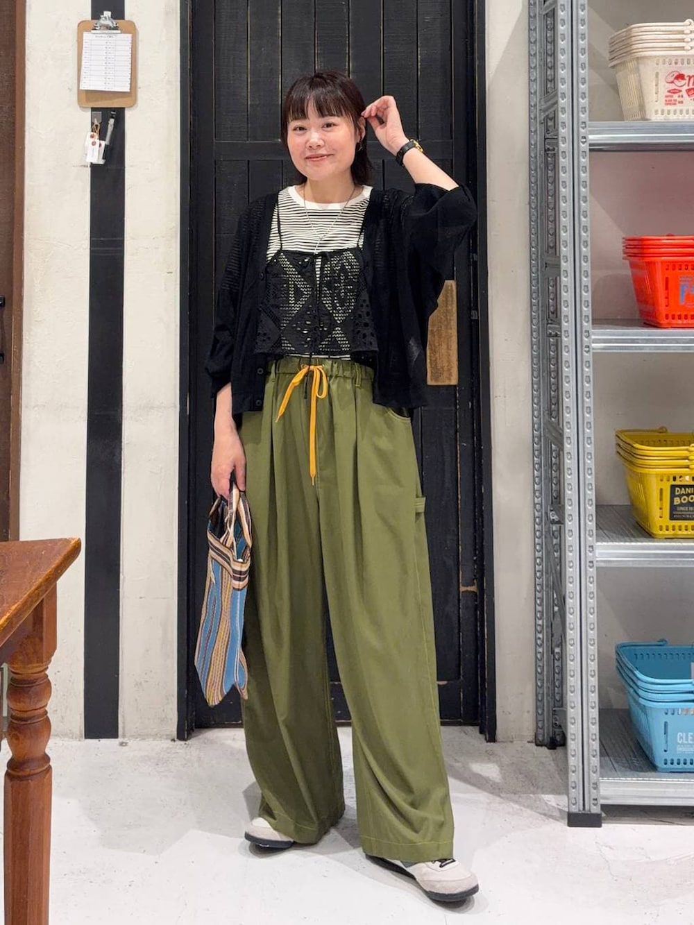 ベージュ系のTシャツ/カットソー、ブラウン系のトートバッグ、ブラック系のカーディガン/ボレロを着用したレディースの春コーディネートの2枚目の写真