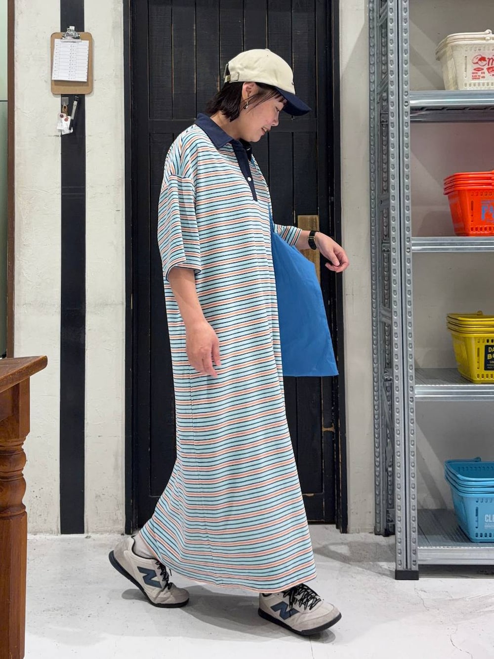 ブルー系のトートバッグ、ブルー系のワンピース、その他のキャップを着用したレディースの春コーディネートの5枚目の写真