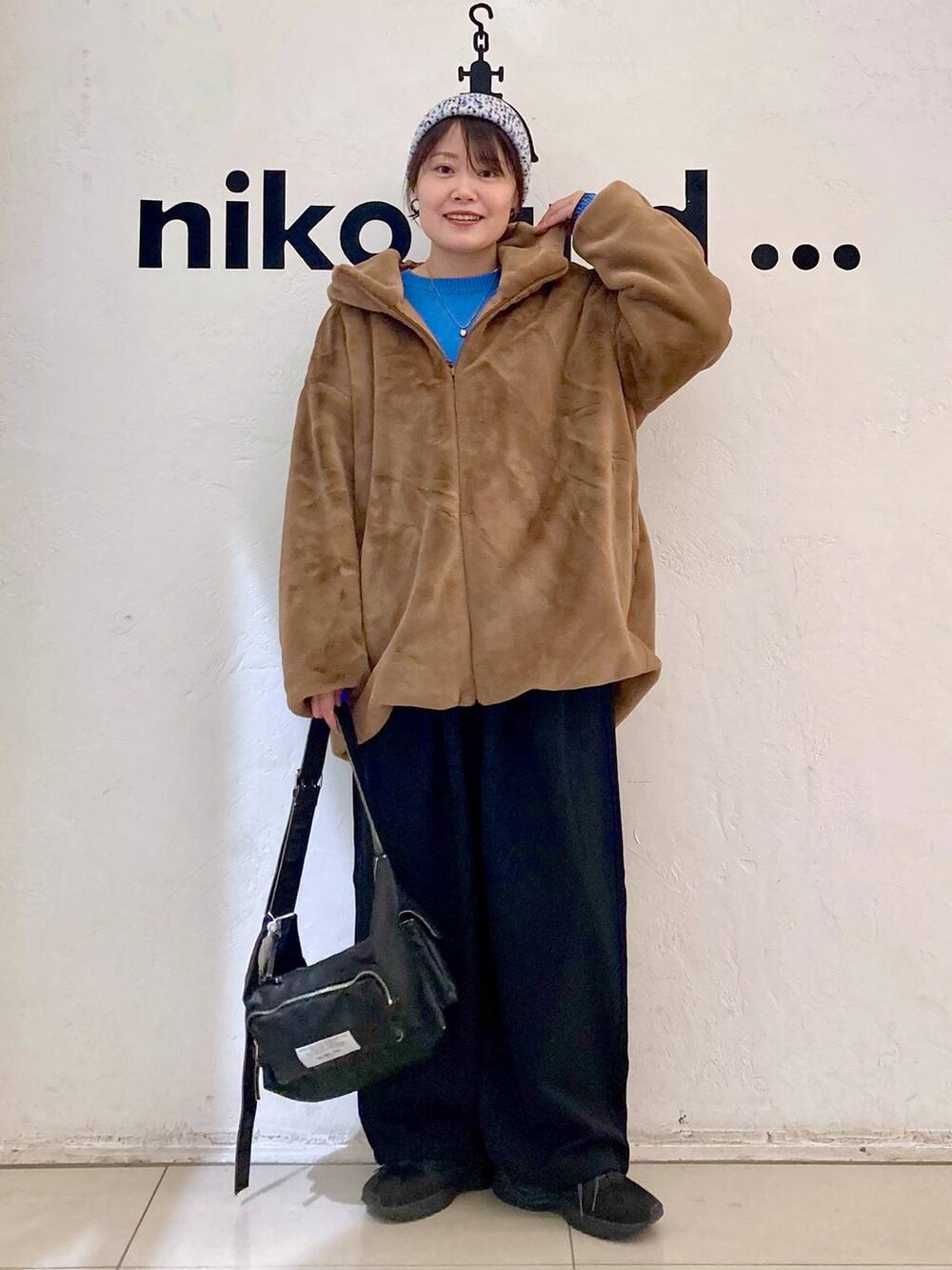 ホワイト系のTシャツ/カットソー、ブルー系のニット/セーター、ブラウン系のブルゾンを着用したレディースの秋コーディネートの3枚目の写真