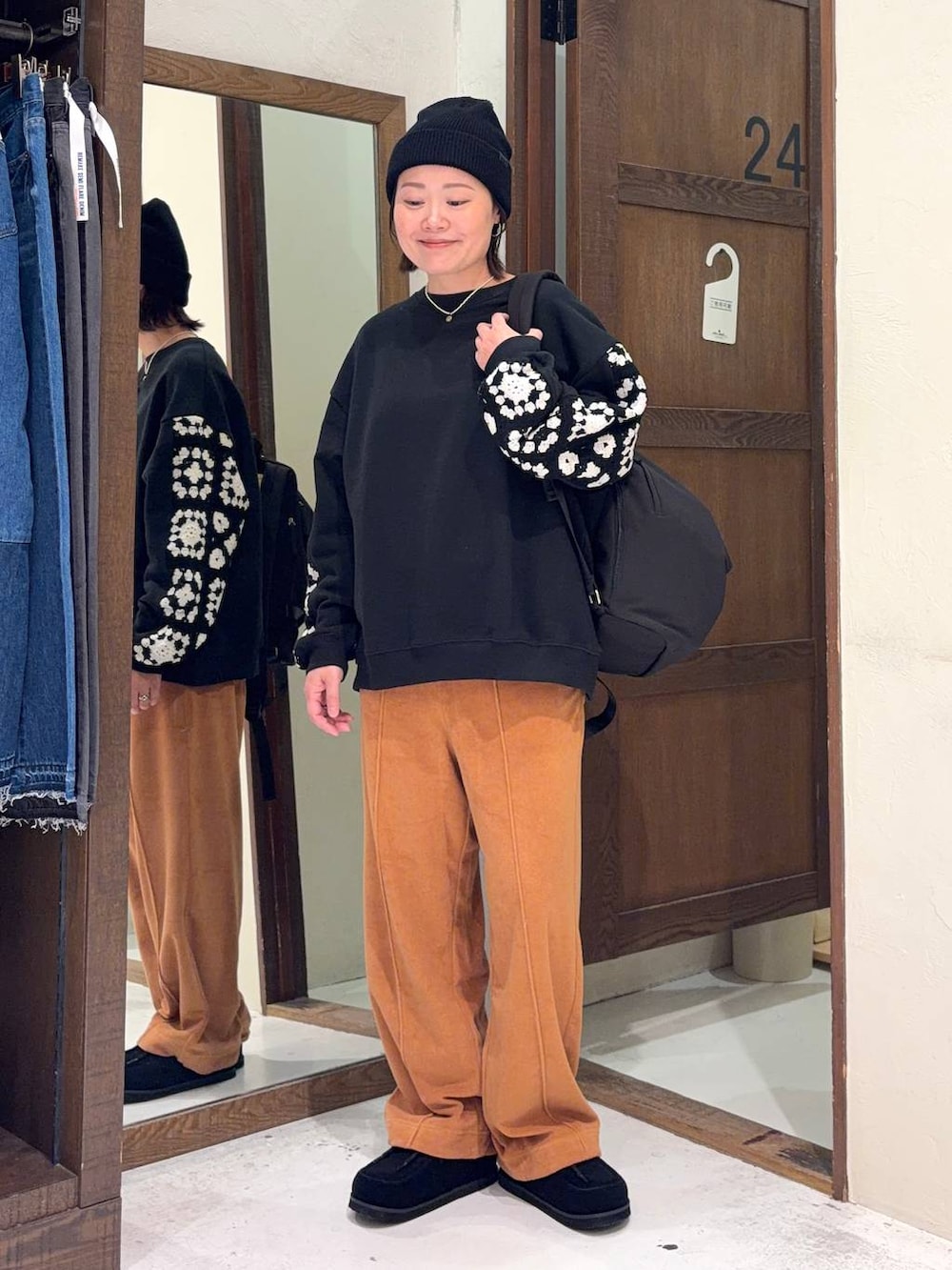 ブラック系のスウェット、オレンジ系のその他パンツ、ブラック系のモカシン/デッキシューズを着用したレディースの春コーディネートの5枚目の写真