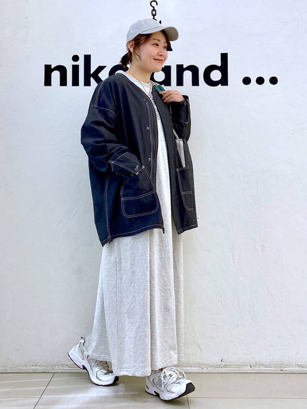 ベージュ系のワンピース、ブラック系のトートバッグ、その他のブルゾンを着用したレディースの春コーディネートの5枚目の写真