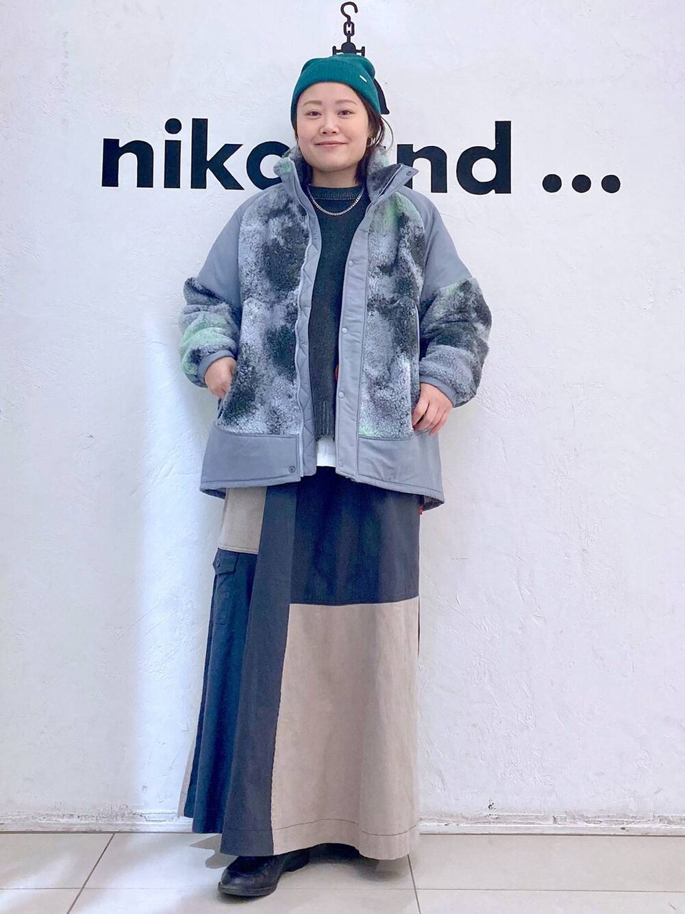 グレー系のブルゾン、ホワイト系のTシャツ/カットソー、グレー系のニット/セーターを着用したレディースの冬コーディネートの3枚目の写真