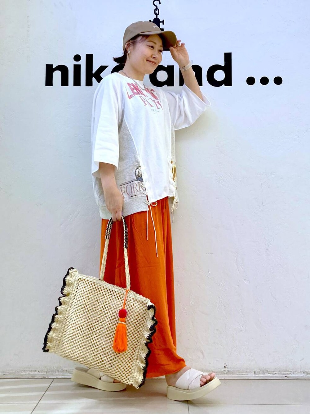 ベージュ系のサンダル、ベージュ系のトートバッグ、ホワイト系のデジタル腕時計を着用したレディースの夏コーディネートの5枚目の写真