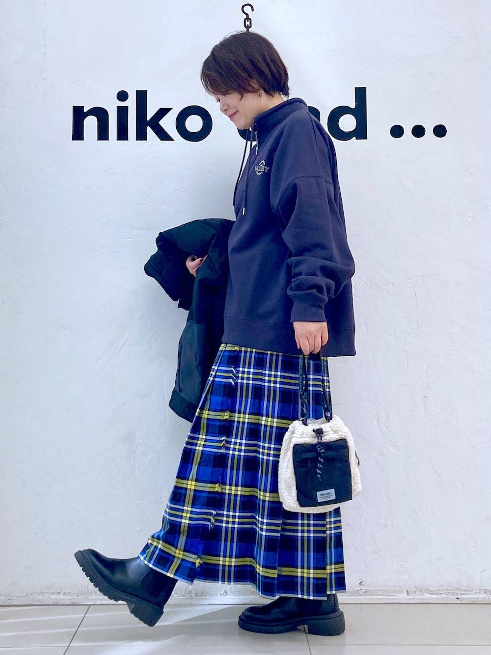 ブルー系のスカート、その他のブルゾン、ブラック系のブーツを着用したレディースの冬コーディネートの3枚目の写真