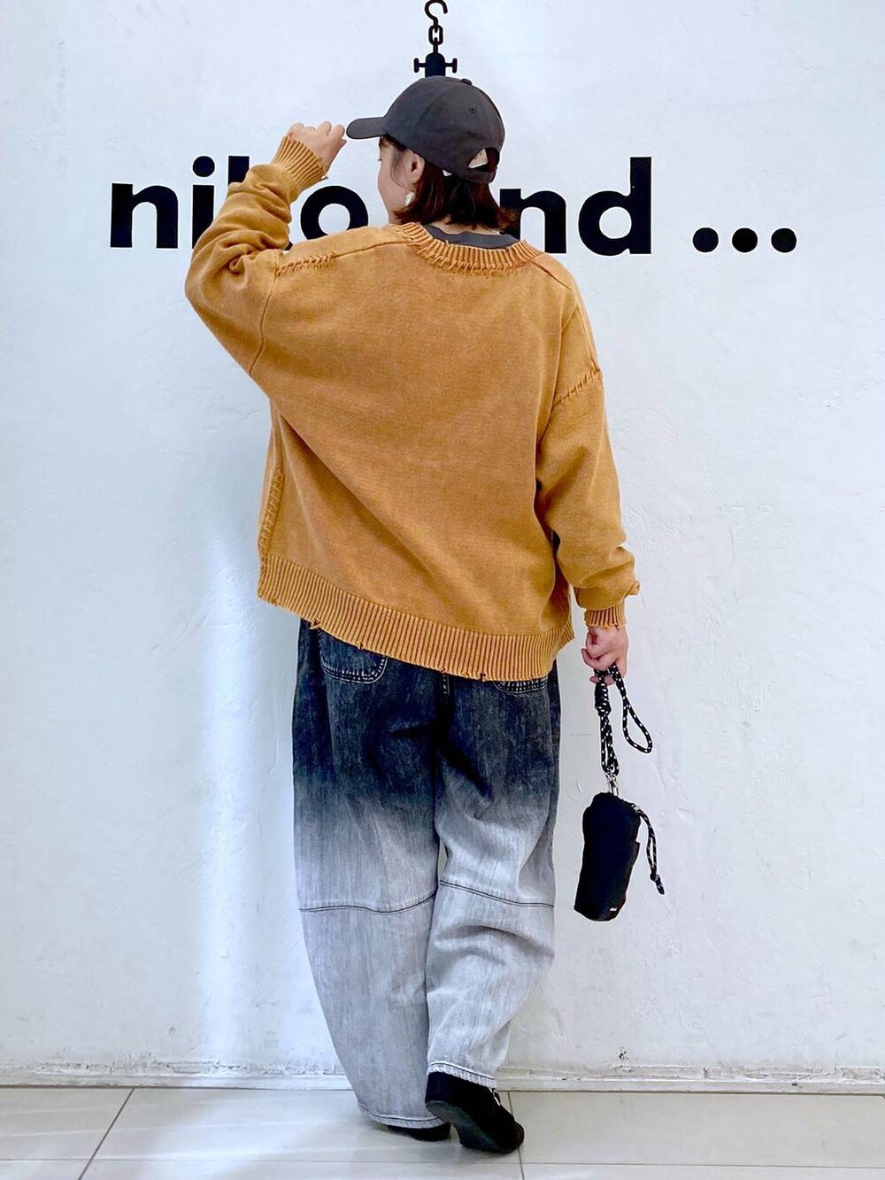 ブラック系のショルダーバッグ、グレー系のTシャツ/カットソー、ブラック系のデニムパンツを着用したレディースの秋コーディネートの4枚目の写真