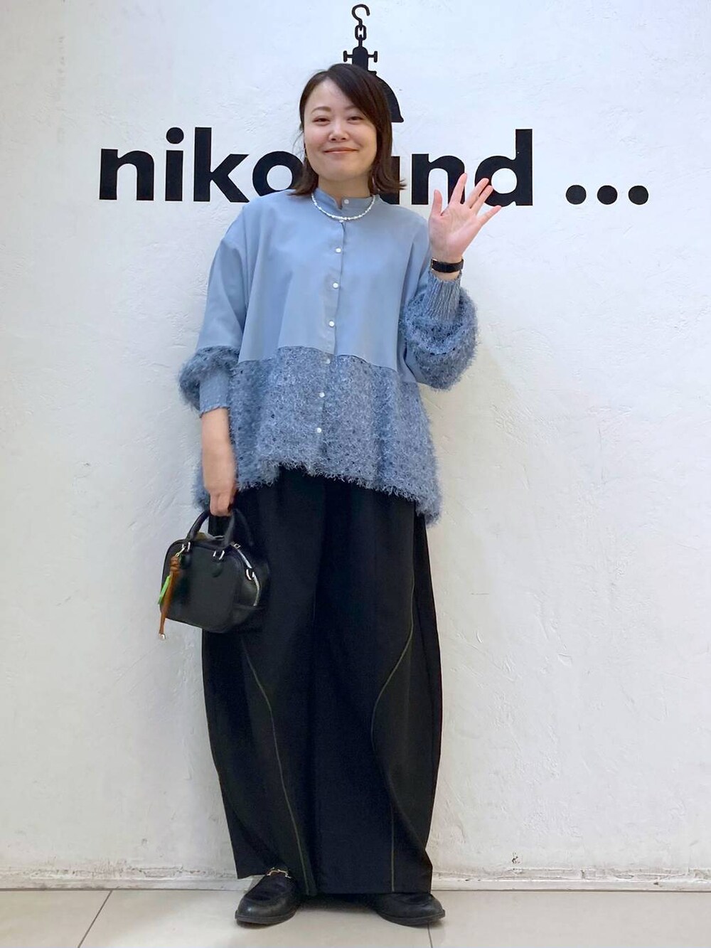 ブラック系のボストンバッグ、ブルー系のシャツ/ブラウス、シルバー系のピアス(両耳用)を着用したレディースの冬コーディネートの2枚目の写真