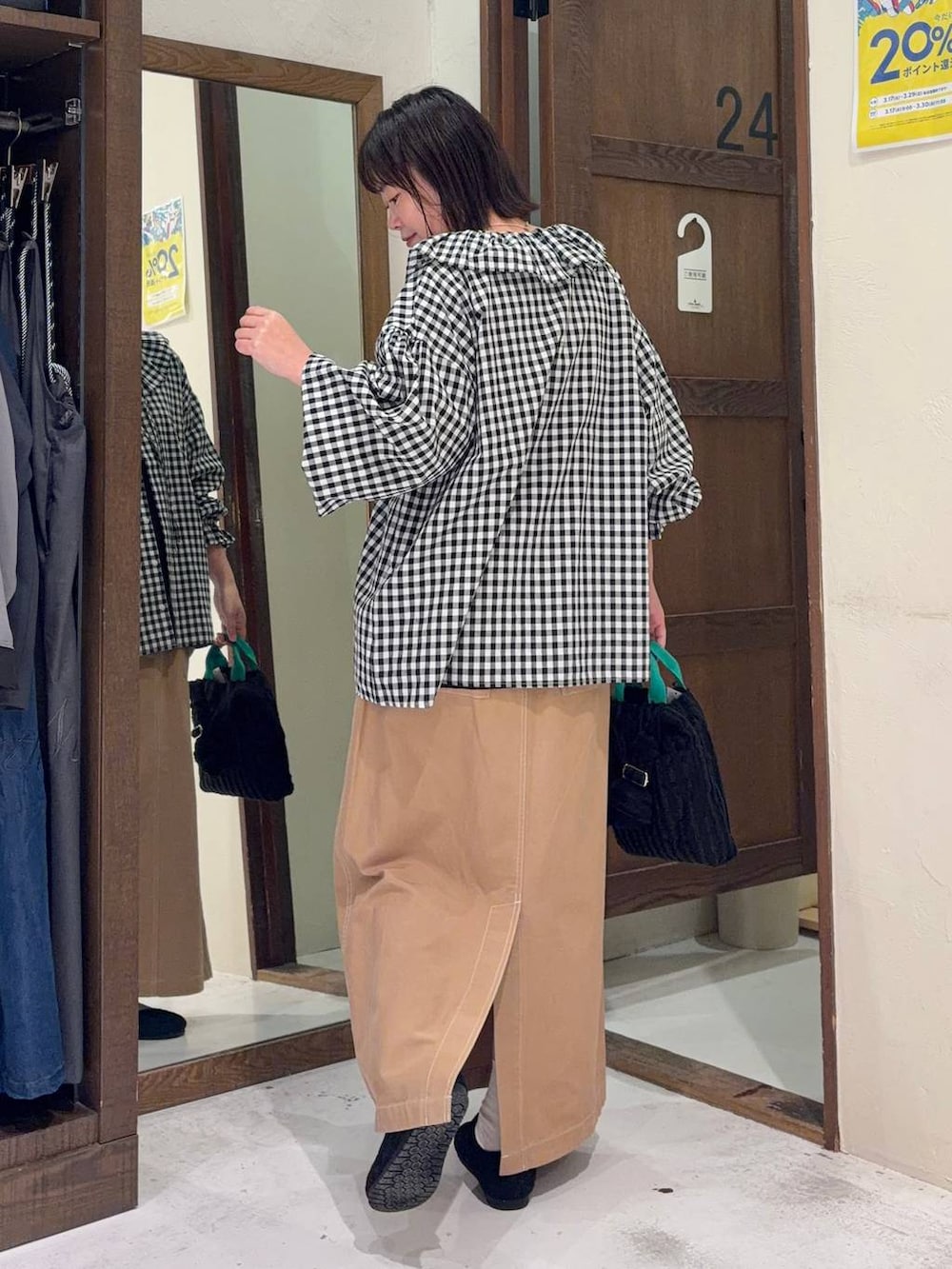 イエロー系のスカート、ブラック系のパンプス、ブラック系のトートバッグを着用したレディースの春コーディネートの3枚目の写真