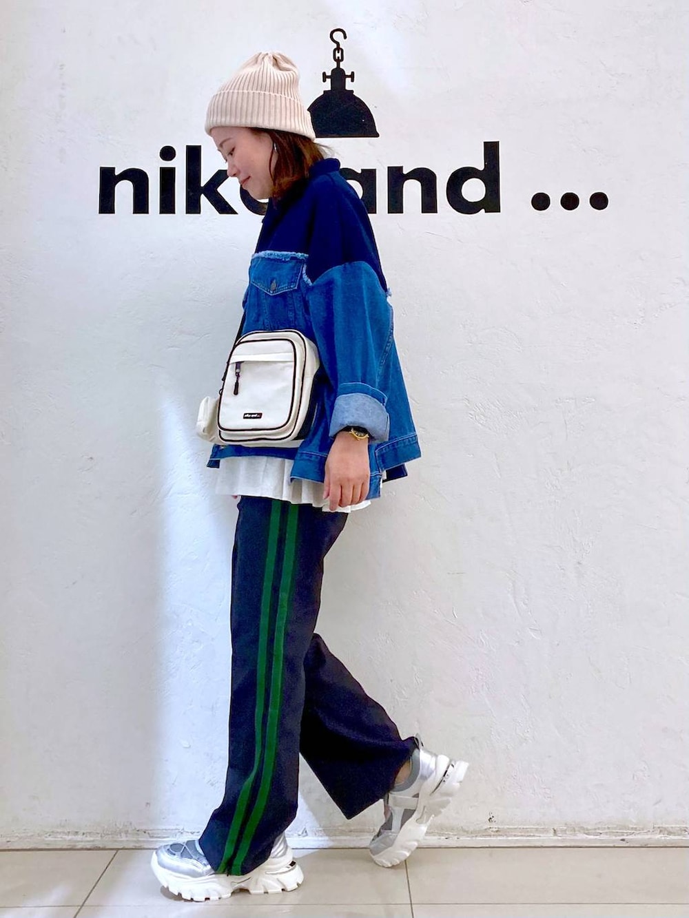 ブルー系のデニムジャケット、ブルー系のその他パンツ、シルバー系のスニーカーを着用したレディースの夏コーディネートの3枚目の写真
