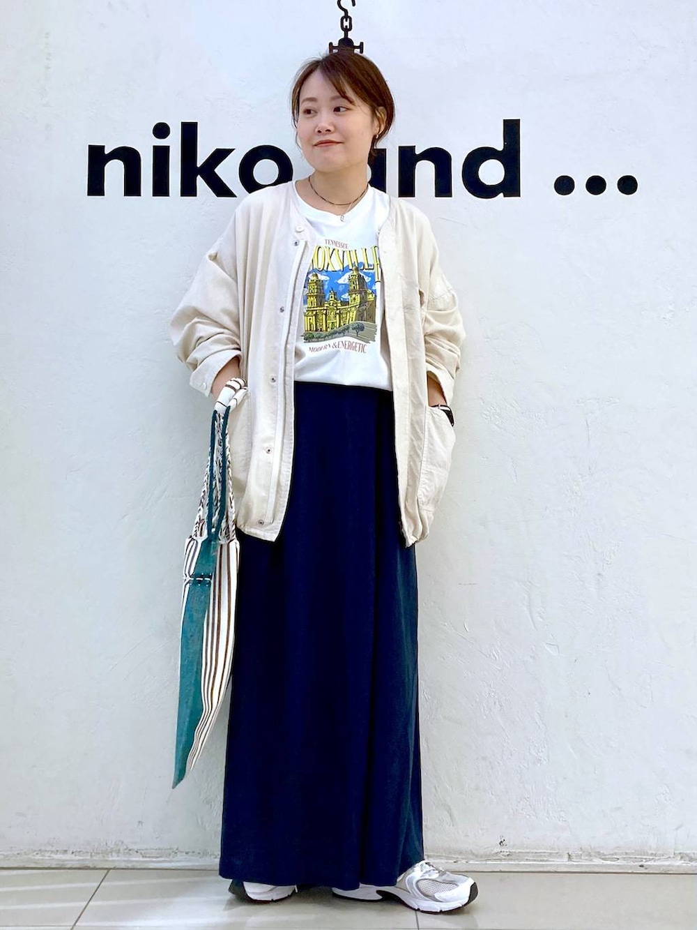 ホワイト系のTシャツ/カットソー、ブラック系のトートバッグ、ベージュ系のブルゾンを着用したレディースの春コーディネートの3枚目の写真