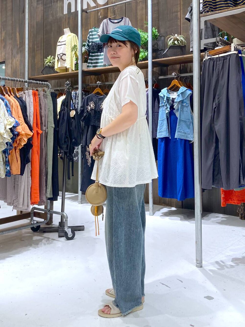 ブルー系のその他パンツ、ホワイト系のベスト、ベージュ系のショルダーバッグを着用したレディースの夏コーディネートの3枚目の写真