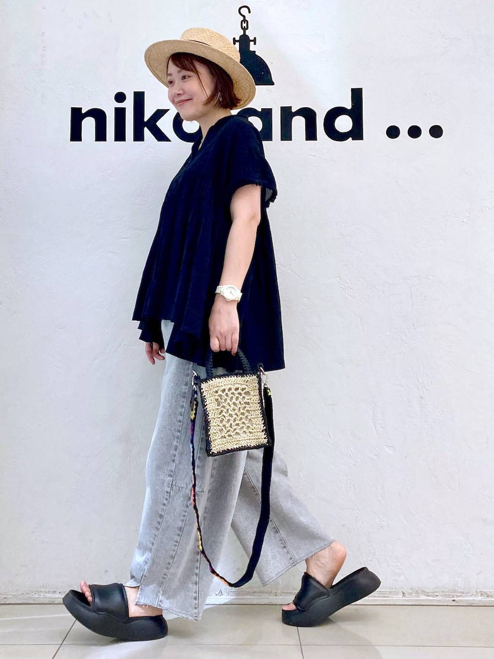 ブラック系のショルダーバッグ、ブラック系のサンダル、グレー系のデニムパンツを着用したレディースの春コーディネートの5枚目の写真