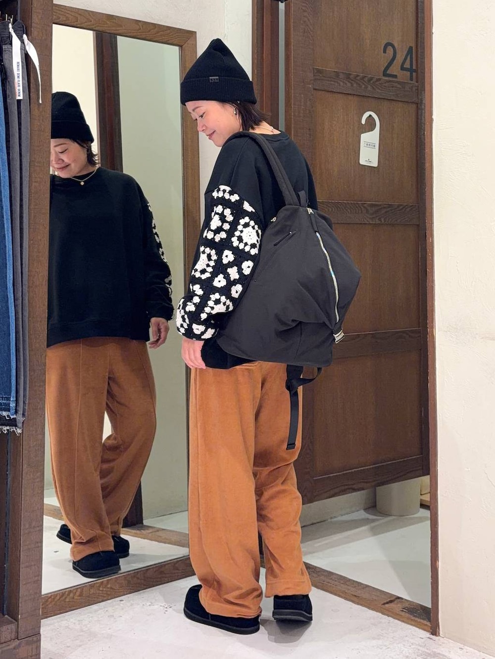 ブラック系のスウェット、オレンジ系のその他パンツ、ブラック系のモカシン/デッキシューズを着用したレディースの春コーディネートの2枚目の写真