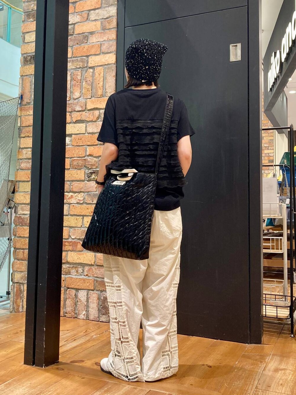 ベージュ系のその他パンツ、ブラック系のTシャツ/カットソー、ブラック系のトートバッグを着用したレディースの夏コーディネートの4枚目の写真