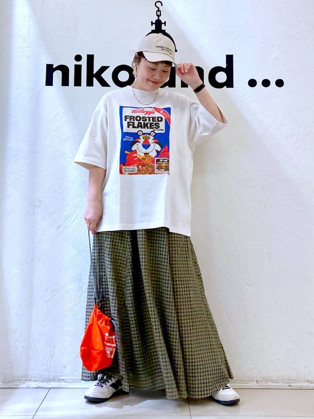 ホワイト系のスニーカー、オレンジ系のショルダーバッグ、ホワイト系のTシャツ/カットソーを着用したレディースの春コーディネートの2枚目の写真