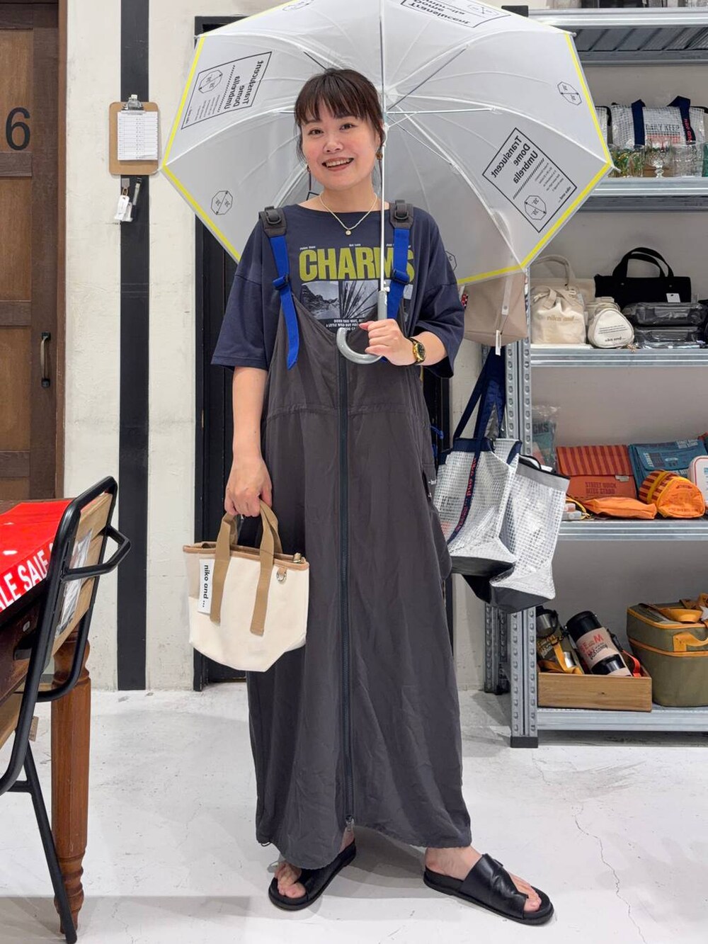 その他のショルダーバッグ、ブルー系のTシャツ/カットソー、ホワイト系の長傘を着用したレディースの夏コーディネートの2枚目の写真